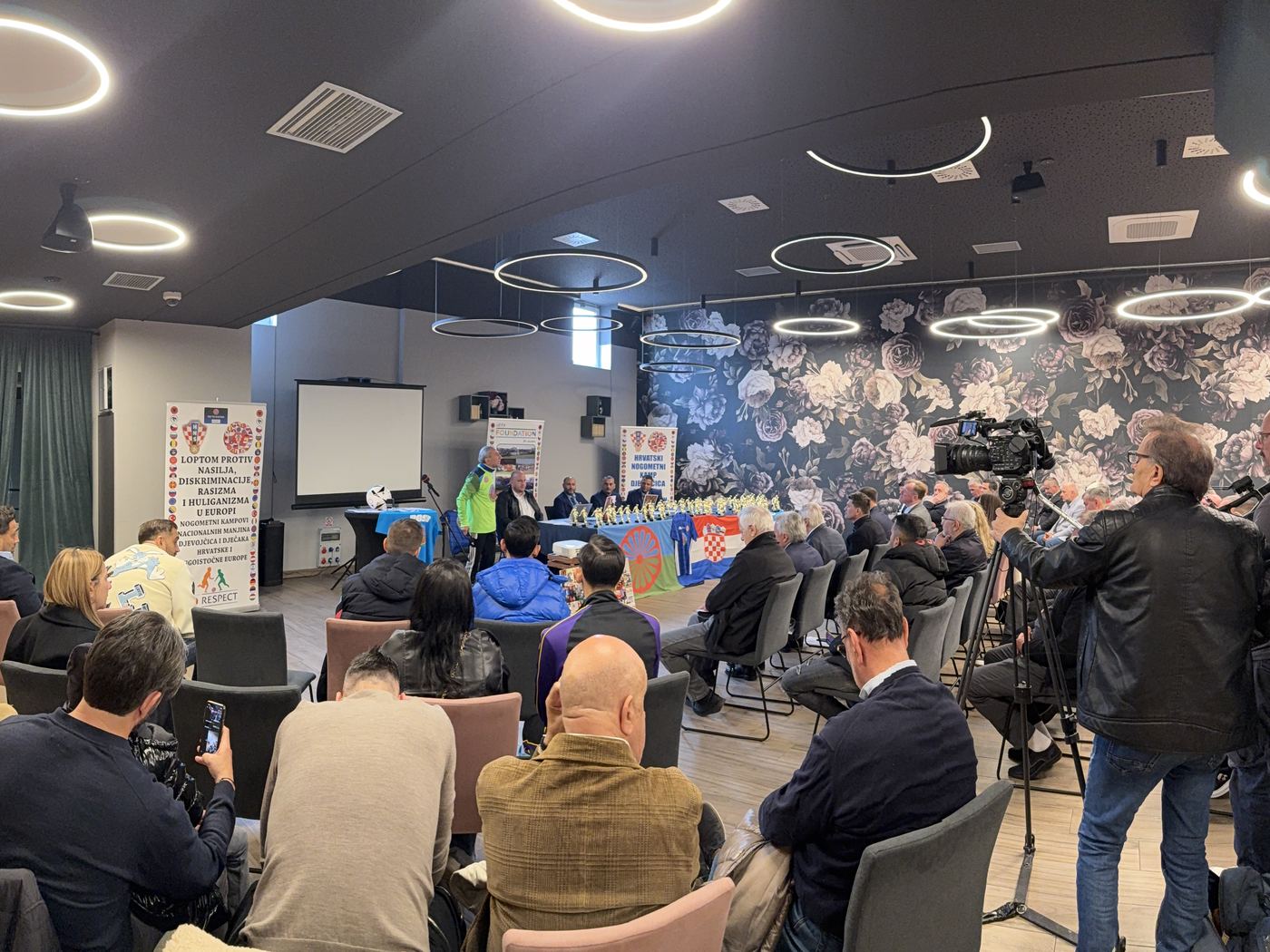 Tisková konference, v popředí kamery a novináři