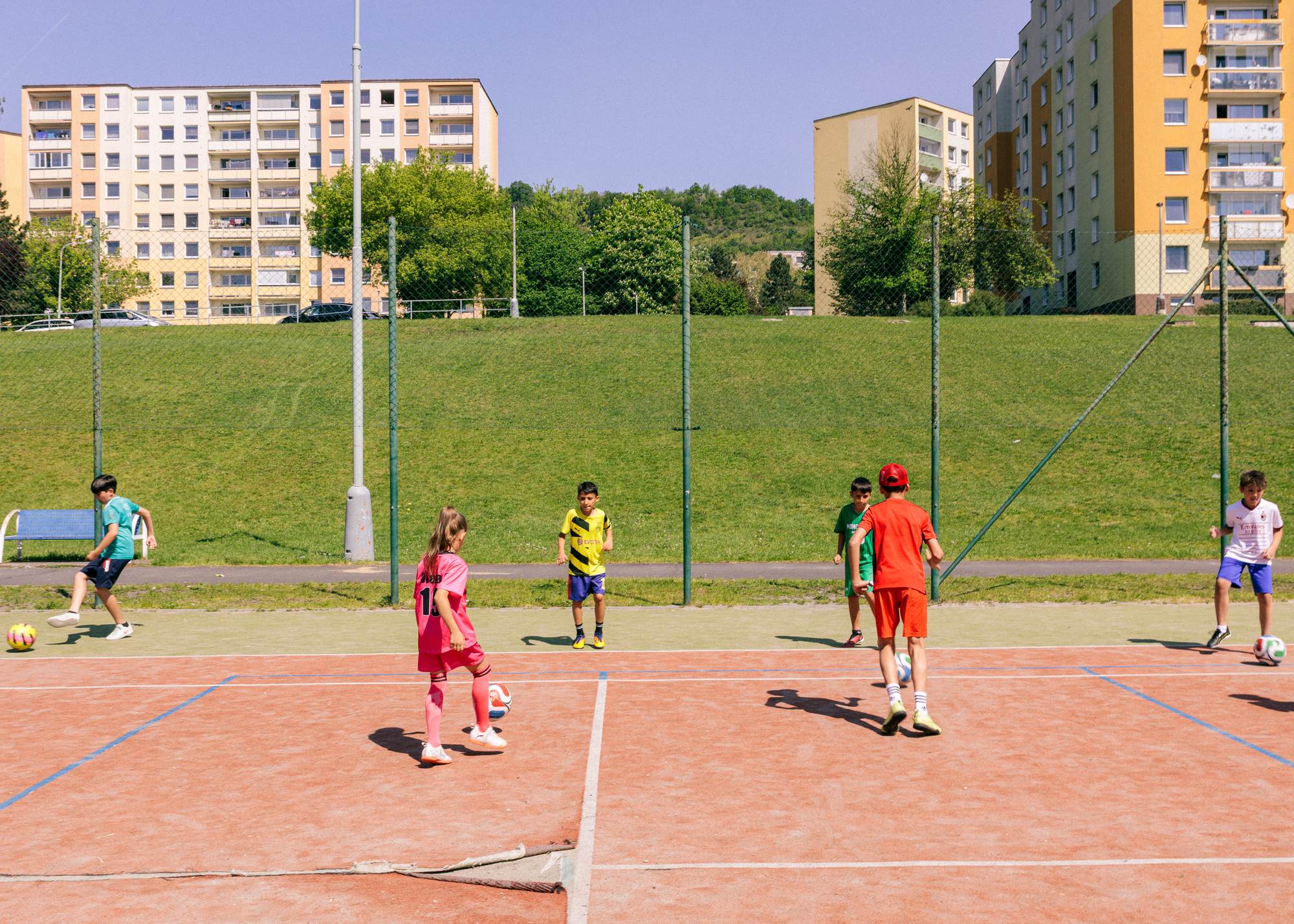 Trénink dětí na antukovém hřišti pod paneláky